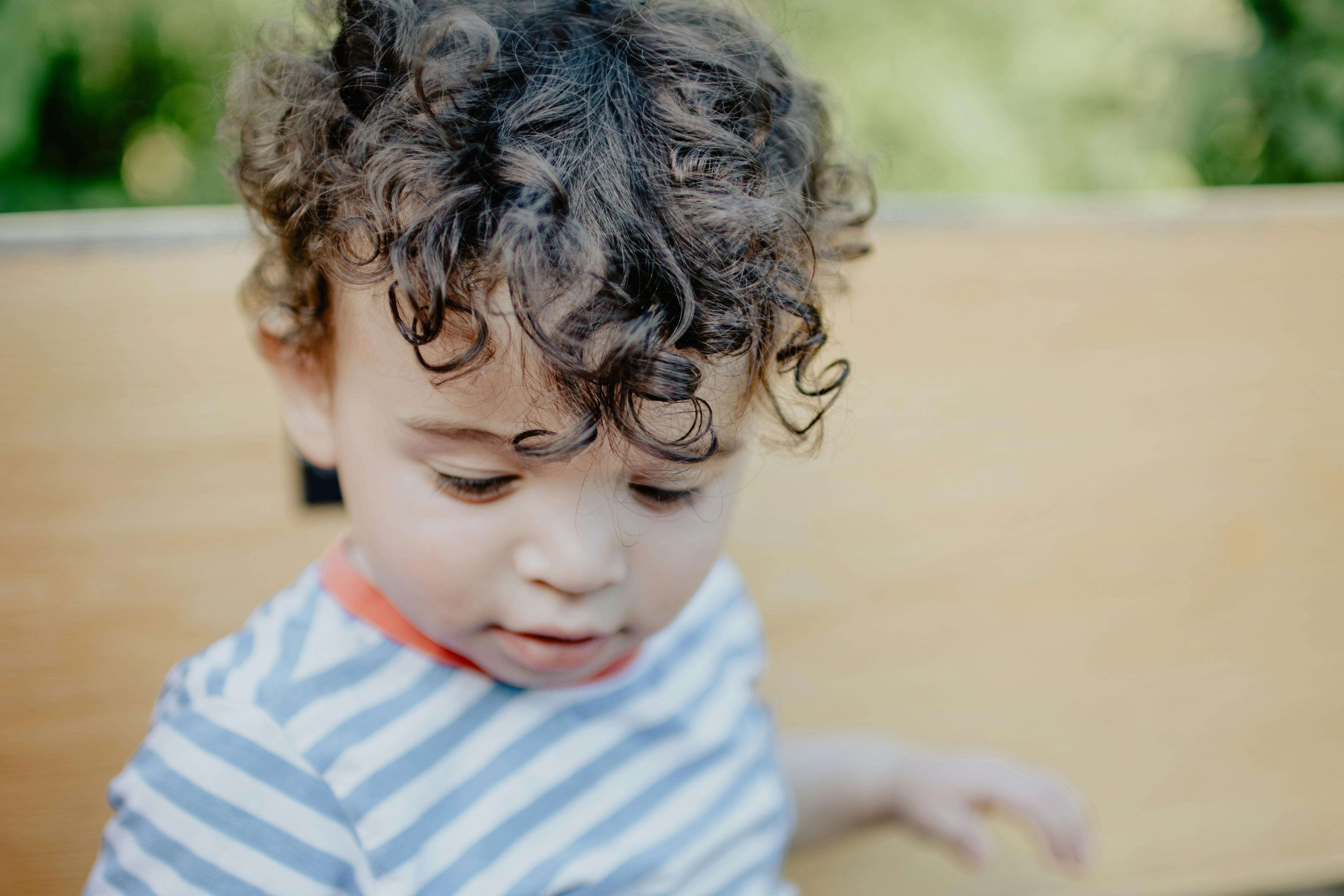 Child with curly hair playing outdoors at The Backyard School preschool in Mesa, Arizona